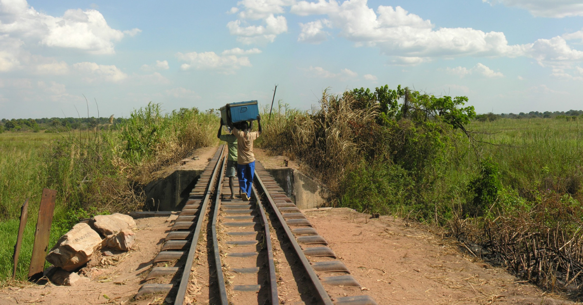 Men carrying boxes along railroad tracks in the Democratic Republic of Congo